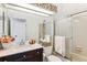 Well-lit bathroom with a shower featuring a sliding door and a dark vanity with marble countertop at 7696 S Monaco E Cir, Centennial, CO 80112