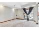 Carpeted room with a sliding glass door, natural light, and gray drapes at 7696 S Monaco E Cir, Centennial, CO 80112