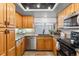 Kitchen features oak cabinets, granite countertops, stainless steel appliances, and a window view at 7696 S Monaco E Cir, Centennial, CO 80112