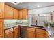 Kitchen featuring oak cabinets, granite countertops, stainless steel appliances, and a window view at 7696 S Monaco E Cir, Centennial, CO 80112