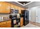 Kitchen featuring oak cabinets, granite countertops, stainless steel appliances, and black appliances at 7696 S Monaco E Cir, Centennial, CO 80112