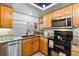 Kitchen featuring oak cabinets, granite countertops, stainless steel appliances, and a window view at 7696 S Monaco E Cir, Centennial, CO 80112