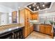 Cozy kitchen featuring wood cabinets, granite countertops, and an attached bar area for seating at 7696 S Monaco E Cir, Centennial, CO 80112