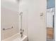 Bathroom with a tub and white tile walls with a grab bar at 2866 Bellaire St, Denver, CO 80207