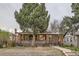 Charming brick home featuring a covered front porch and mature landscaping at 2866 Bellaire St, Denver, CO 80207