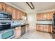 Kitchen with wooden cabinets, tile backsplash, stainless steel appliances, and tiled floor at 2866 Bellaire St, Denver, CO 80207