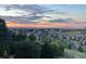 A picturesque view of a residential community at sunset, showcasing a mix of homes and lush greenery at 10662 Skydance Dr, Highlands Ranch, CO 80126