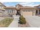 Charming home featuring a stone facade, tiled roof, well-maintained landscaping, and a two-car garage at 10662 Skydance Dr, Highlands Ranch, CO 80126