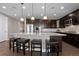 Well-lit kitchen with dark wood cabinets, stainless appliances, large island, and comfortable barstool seating at 10662 Skydance Dr, Highlands Ranch, CO 80126
