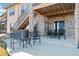 A covered patio area features stone supports, an outdoor dining table, and chairs at 10662 Skydance Dr, Highlands Ranch, CO 80126