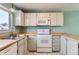 Bright kitchen features white appliances, tile flooring, wood countertops, and natural light, offering a functional cooking space at 8635 Clay St # 417, Westminster, CO 80031
