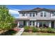 Charming two-story townhome features a covered porch, gray siding, a well-manicured lawn, and beautiful landscaping at 10016 Hough Pt, Parker, CO 80134