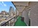 Unit balcony includes turf, dark metal railing, chairs, and city views at 100 S Clarkson St # 303, Denver, CO 80209