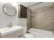 Bathroom featuring tile flooring, tile shower, and a round mirror at 100 S Clarkson St # 303, Denver, CO 80209