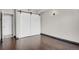 Bedroom features hardwood floors, abundant natural light, and custom barn doors at 100 S Clarkson St # 303, Denver, CO 80209