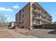 Exterior corner shot features open-air balconies and a gray parking area at 100 S Clarkson St # 303, Denver, CO 80209
