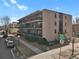 Exterior shot of the building features open-air balconies and a sidewalk at 100 S Clarkson St # 303, Denver, CO 80209