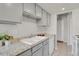 Galley kitchen featuring gray cabinets, granite countertops, white appliances, and tile flooring at 100 S Clarkson St # 303, Denver, CO 80209