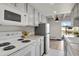 Galley kitchen featuring gray cabinets, granite countertops, and white appliances at 100 S Clarkson St # 303, Denver, CO 80209