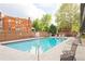 Community pool is open with clear blue water, lounge chairs, and mature trees at 100 S Clarkson St # 303, Denver, CO 80209