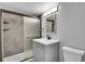 Updated bathroom with shower stall, frosted glass door and gray vanity at 1255 Nelson St, Lakewood, CO 80215