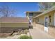 A bright tan home with a brick accent foundation and a sidewalk leading to a storm door at 1255 Nelson St, Lakewood, CO 80215