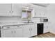A bright kitchen with white marble countertops, white cabinets, and stainless steel appliances at 1255 Nelson St, Lakewood, CO 80215