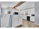 A brightly lit kitchen with white cabinets, black appliances, and wood laminate flooring at 1255 Nelson St, Lakewood, CO 80215