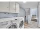 Bright laundry room with LG washer/dryer set, white cabinets, and wood-look flooring at 1255 Nelson St, Lakewood, CO 80215
