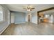 Spacious living room featuring new floors, a ceiling fan, and a kitchen with stainless steel appliances at 1255 Nelson St, Lakewood, CO 80215