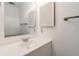 Bright bathroom featuring a white vanity, sink, and a mirrored wall cabinet at 1050 S Monaco Pkwy # 77, Denver, CO 80224