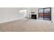An empty living room showcasing the fireplace, and sliding glass doors at 1050 S Monaco Pkwy # 77, Denver, CO 80224