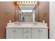 Bathroom featuring double sinks with white cabinetry, large mirrors, and vanity lighting at 120 S Locust St, Denver, CO 80224