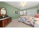 Bright bedroom with a floral-patterned quilt, ceiling fan, and soft natural light at 120 S Locust St, Denver, CO 80224