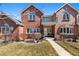 Inviting two-story brick home with walkway, balcony, arched windows, and mature landscaped front yard at 120 S Locust St, Denver, CO 80224