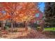 Charming red brick home with iron gate, mature trees with bright fall foliage, and manicured landscaping at 120 S Locust St, Denver, CO 80224