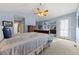 Spacious main bedroom with blue walls, carpet, ceiling fan, and sitting area leading to a door at 120 S Locust St, Denver, CO 80224