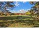 Scenic park view with a bench, colorful fall foliage, and a house in the distance at 120 S Locust St, Denver, CO 80224
