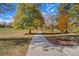 Cement path through a lush community space with mature trees in fall colors under a blue sky at 120 S Locust St, Denver, CO 80224
