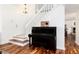 Welcoming entrance featuring a piano, staircase, and hardwood floors at 1314 Ascot Ave, Highlands Ranch, CO 80126