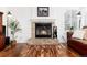 Close-up of a brick fireplace, hardwood floors, and art for a cozy ambiance in the living room at 1314 Ascot Ave, Highlands Ranch, CO 80126