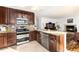 Modern kitchen featuring stainless steel appliances, granite countertops, and rich wood cabinetry at 1314 Ascot Ave, Highlands Ranch, CO 80126