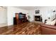Spacious living room featuring hardwood floors, a brick fireplace, and a large entertainment center at 1314 Ascot Ave, Highlands Ranch, CO 80126