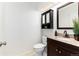 Updated powder room featuring granite countertops, dark wood vanity, and decorative mirror at 1314 Ascot Ave, Highlands Ranch, CO 80126