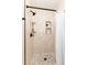 Walk-in shower features stone tile, a modern shower head, and sleek fixtures at 1314 Ascot Ave, Highlands Ranch, CO 80126