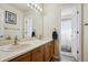 Bathroom featuring a dual sink vanity, tile flooring and a view to the shower over tub at 9457 Morning Glory Ln, Highlands Ranch, CO 80130