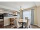 Bright dining area features hardwood floors, a modern chandelier, and seamless access to a modern kitchen at 9457 Morning Glory Ln, Highlands Ranch, CO 80130