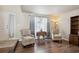 Cozy living room with neutral paint, hardwood floors and comfy arm chairs at 9457 Morning Glory Ln, Highlands Ranch, CO 80130