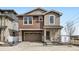Two-story home featuring a two-car garage, stone accents, and covered entry at 2098 S Haleyville Way, Aurora, CO 80018