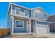 Charming blue home with white trim, a covered porch, and an attached two-car garage at 6531 14Th St, Frederick, CO 80530
